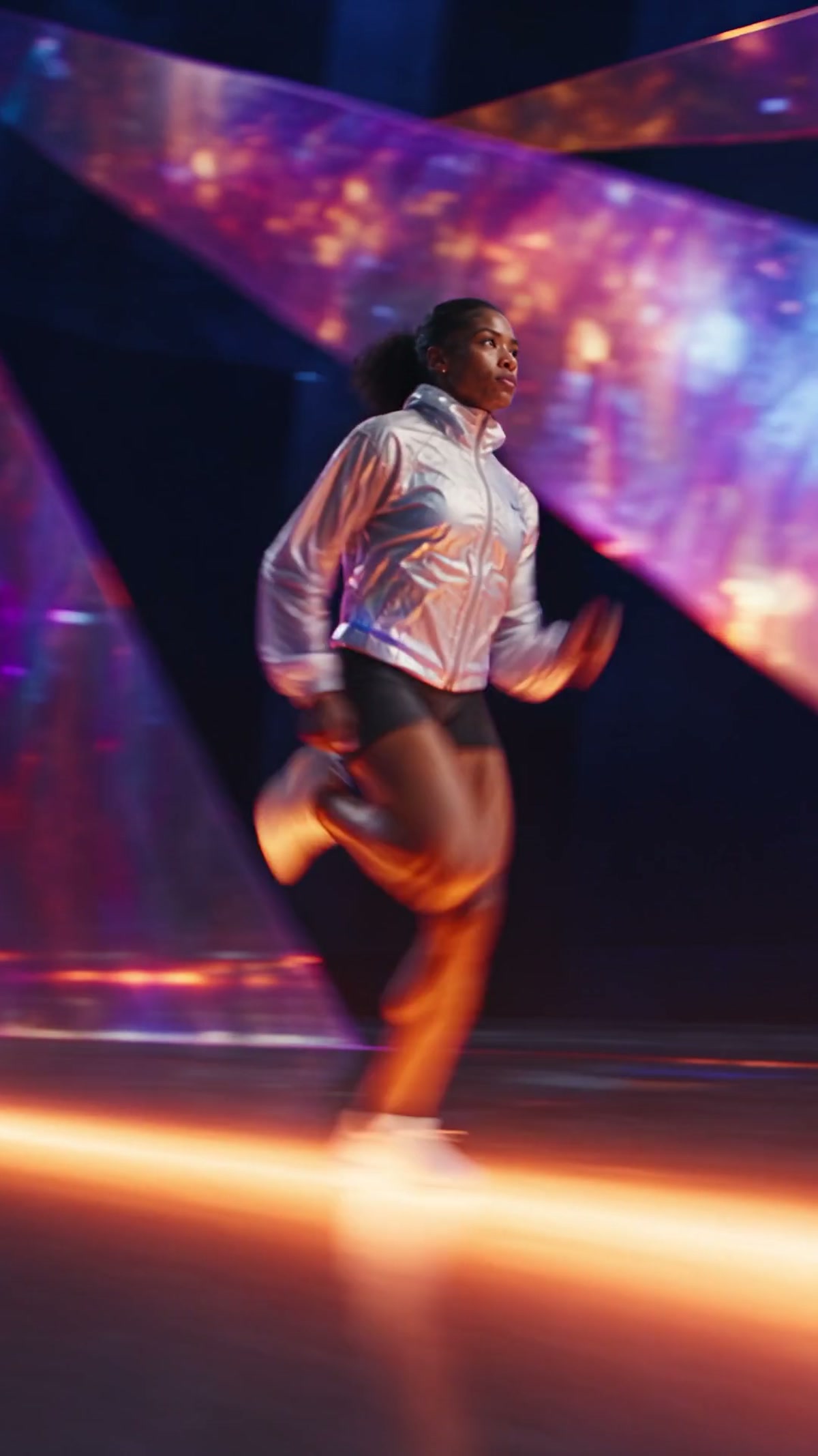 Biegaczka w srebrnej kurtce na świetlistym torze